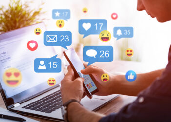 Like and share social media. Hands holding smartphone with social media network icons. Marketing concept.