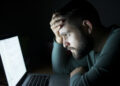 Man in front of the laptop reading and being concentrated.